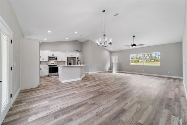 Chandelier, Empty room, Interior, Kitchen, Pendant Lights, Recessed Lighting, Stainless Steel Appliances, Wood Texture Flooring