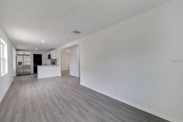 Empty room, Interior, Kitchen, Recessed Lighting, Stainless Steel Appliances, Wood Texture Flooring