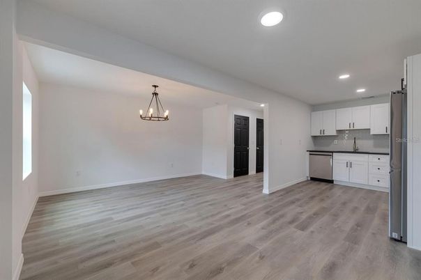 Chandelier, Empty room, Interior, Kitchen, Pendant Lights, Recessed Lighting, Stainless Steel Appliances, Wood Texture Flooring