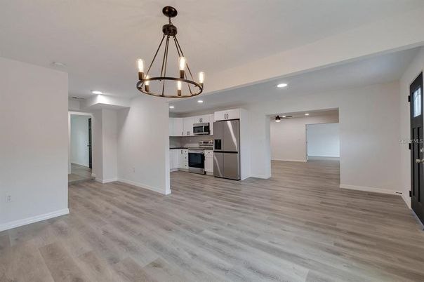 Chandelier, Empty room, Interior, Kitchen, Pendant Lights, Recessed Lighting, Stainless Steel Appliances, Wood Texture Flooring