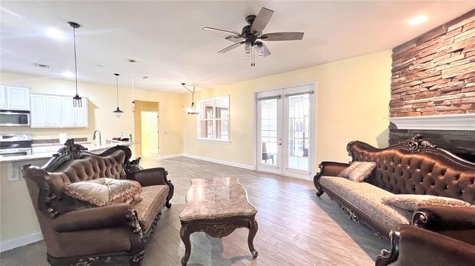 Fireplace, Interior, Kitchen, Living room, Pendant Lights, Recessed Lighting, Stainless Steel Appliances, Stone Walls, Wood Texture Flooring