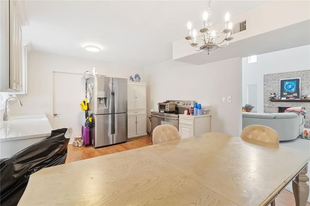 Chandelier, Dining room, Interior, Kitchen, Living room, Recessed Lighting, Stainless Steel Appliances, Stone Walls, Wood Texture Flooring