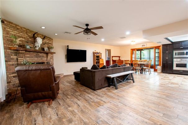 Dining room, Fireplace, Interior, Kitchen, Living room, Recessed Lighting, Stainless Steel Appliances, Stone Walls, Wood Texture Flooring