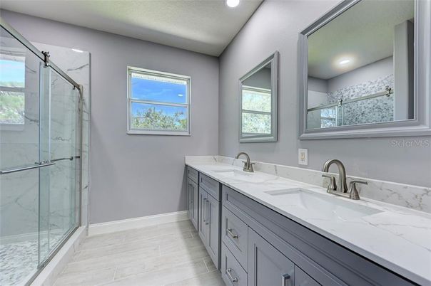 Bathroom, Dual Sink Vanities, Glass Shower, Interior, Marble Walls, Recessed Lighting, Wood Texture Flooring