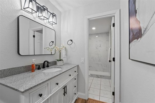 Bathroom, Dual Sink Vanities, Interior, Marble, Marble Walls, Recessed Lighting, Wood Texture Flooring