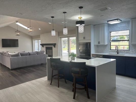 Fireplace, Interior, Kitchen, Living room, Pendant Lights, Recessed Lighting, Stone Walls, Wood Texture Flooring