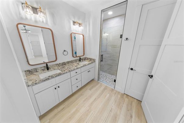Bathroom, Dual Sink Vanities, Glass Shower, Interior, Recessed Lighting, Wood Texture Flooring