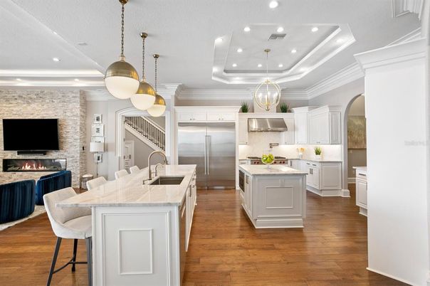 Fireplace, Interior, Kitchen, Pendant Lights, Recessed Lighting, Stainless Steel Appliances, Stone Walls, Wood Texture Flooring
