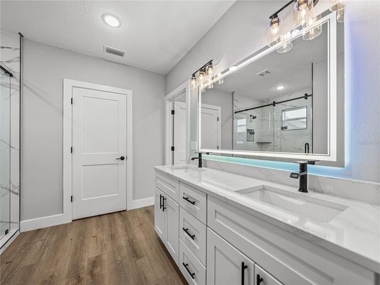 Bathroom, Dual Sink Vanities, Glass Shower, Interior, Recessed Lighting, Wood Texture Flooring