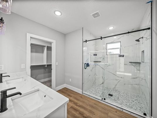 Bathroom, Dual Sink Vanities, Glass Shower, Interior, Marble Walls, Recessed Lighting, Wood Texture Flooring