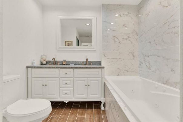 Bathroom, Dual Sink Vanities, Interior, Marble Walls, Recessed Lighting, Wood Texture Flooring
