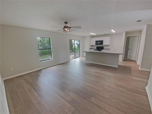 Empty room, Interior, Kitchen, Recessed Lighting, Stainless Steel Appliances, Wood Texture Flooring