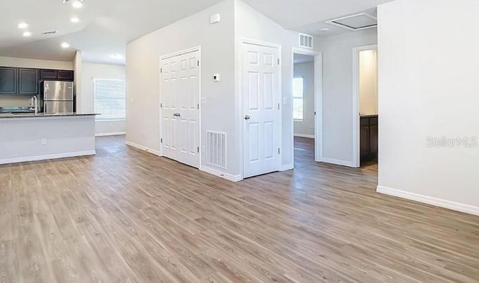 Empty room, Interior, Kitchen, Recessed Lighting, Stainless Steel Appliances, Wood Texture Flooring