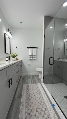 Bathroom, Dual Sink Vanities, Glass Shower, Interior, Recessed Lighting, Wood Texture Flooring