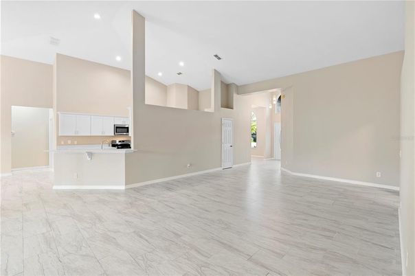 Empty room, Interior, Kitchen, Recessed Lighting, Stainless Steel Appliances, Wood Texture Flooring