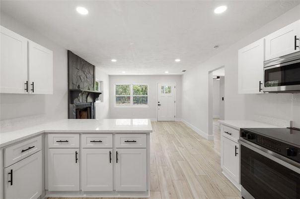 Fireplace, Interior, Kitchen, Recessed Lighting, Stainless Steel Appliances, Wood Texture Flooring