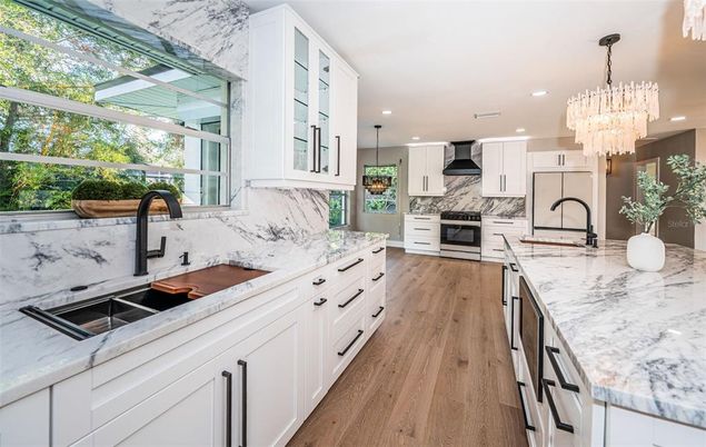 Chandelier, Interior, Kitchen, Marble Walls, Pendant Lights, Recessed Lighting, Stainless Steel Appliances, Wood Texture Flooring