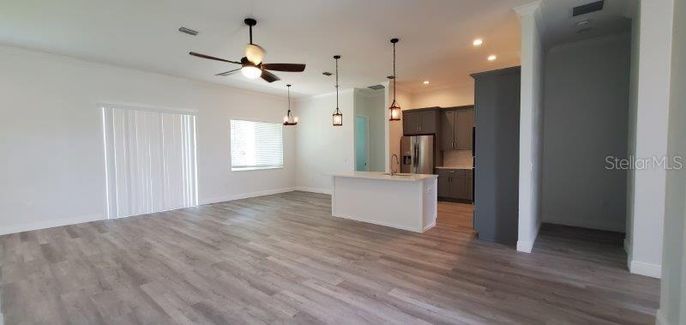 Empty room, Interior, Kitchen, Pendant Lights, Recessed Lighting, Stainless Steel Appliances, Wood Texture Flooring