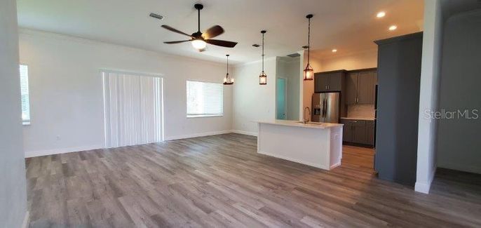 Empty room, Interior, Kitchen, Pendant Lights, Recessed Lighting, Stainless Steel Appliances, Wood Texture Flooring