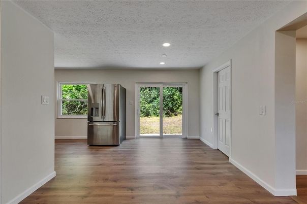 Empty room, Interior, Kitchen, Recessed Lighting, Stainless Steel Appliances, Wood Texture Flooring