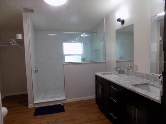 Bathroom, Dual Sink Vanities, Glass Shower, Interior, Marble Walls, Wood Texture Flooring