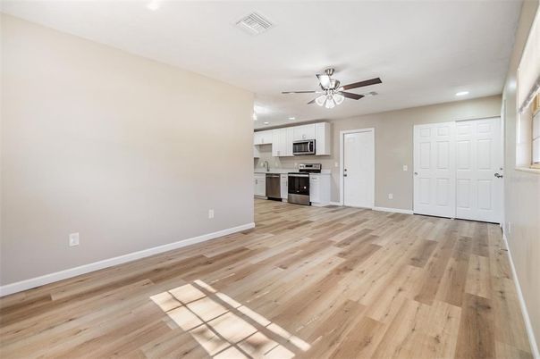 Empty room, Interior, Kitchen, Recessed Lighting, Stainless Steel Appliances, Wood Texture Flooring