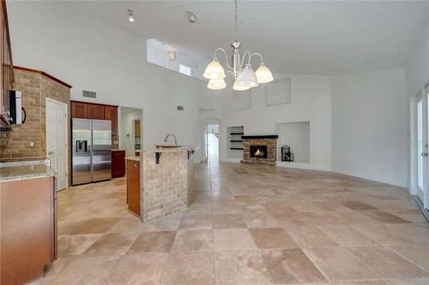 Chandelier, Empty room, Fireplace, Interior, Kitchen, Pendant Lights, Stainless Steel Appliances, Stone Walls