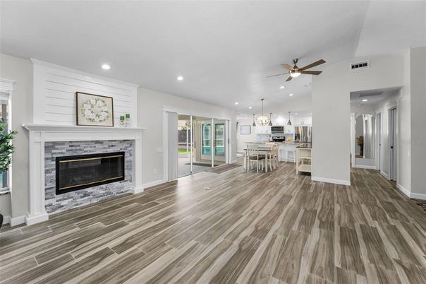 Chandelier, Dining room, Empty room, Fireplace, Interior, Kitchen, Pendant Lights, Recessed Lighting, Stainless Steel Appliances, Wood Texture Flooring