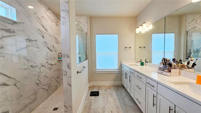 Bathroom, Dual Sink Vanities, Interior, Marble Walls, Recessed Lighting, Wood Texture Flooring