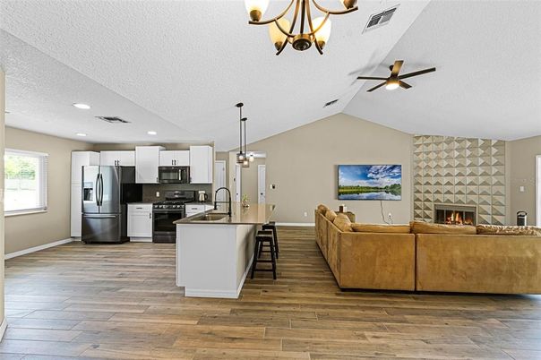 Fireplace, Interior, Kitchen, Living room, Pendant Lights, Recessed Lighting, Stainless Steel Appliances, Wood Texture Flooring
