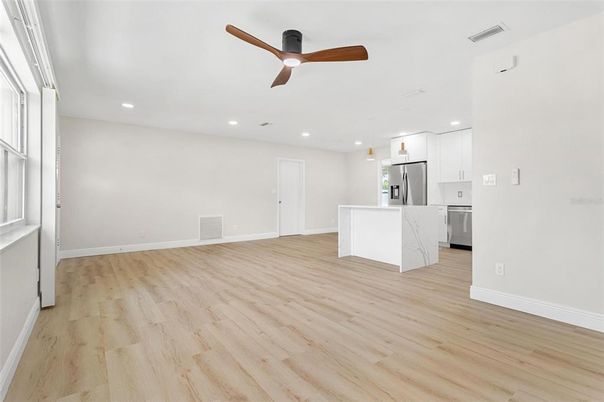 Empty room, Interior, Kitchen, Recessed Lighting, Stainless Steel Appliances, Wood Texture Flooring