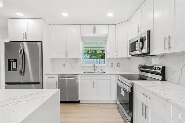 Interior, Kitchen, Marble Walls, Recessed Lighting, Stainless Steel Appliances, Wood Texture Flooring