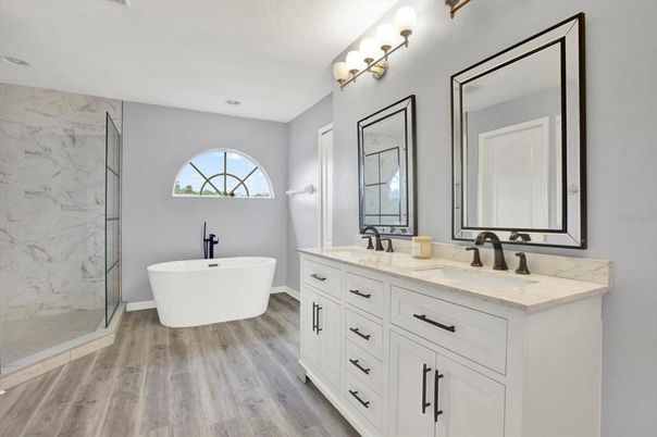 Bathroom, Dual Sink Vanities, Free Standing Baths, Glass Shower, Interior, Marble Walls, Recessed Lighting, Wood Texture Flooring