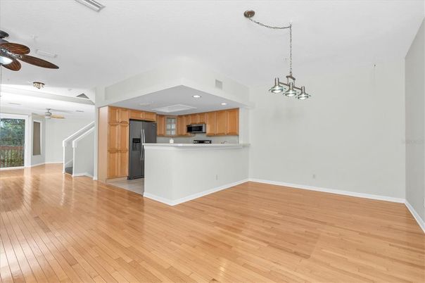 Chandelier, Empty room, Interior, Kitchen, Pendant Lights, Recessed Lighting, Stainless Steel Appliances, Wood Texture Flooring