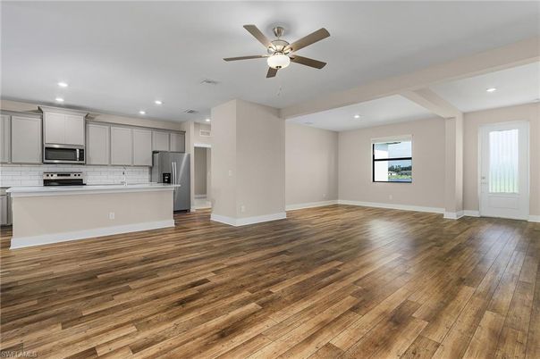 Empty room, Interior, Kitchen, Recessed Lighting, Stainless Steel Appliances, Wood Texture Flooring
