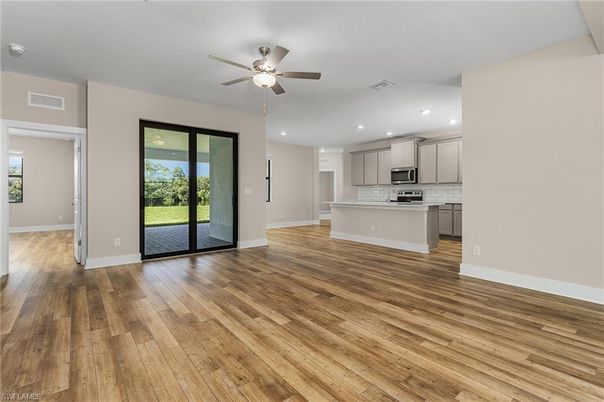 Empty room, Interior, Kitchen, Recessed Lighting, Stainless Steel Appliances, Wood Texture Flooring