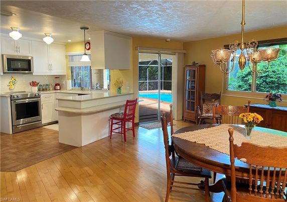 Chandelier, Dining room, Interior, Kitchen, Pendant Lights, Recessed Lighting, Stainless Steel Appliances, Wood Texture Flooring