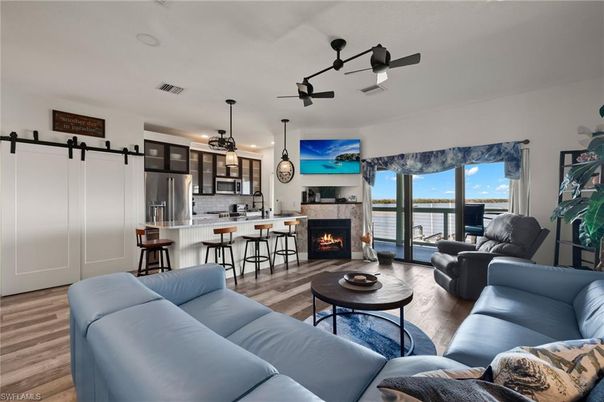 Fireplace, Interior, Kitchen, Living room, Pendant Lights, Recessed Lighting, Stainless Steel Appliances, Water, Wood Texture Flooring