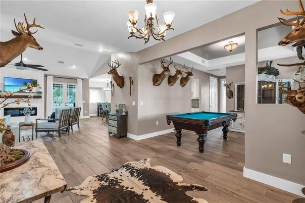 Billiard Table, Chandelier, Fireplace, Game Room, Interior, Living room, Recessed Lighting, Wood Texture Flooring