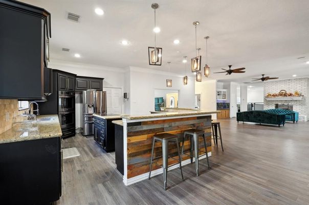 Fireplace, Interior, Kitchen, Pendant Lights, Recessed Lighting, Stainless Steel Appliances, Stone Walls, Wood Texture Flooring
