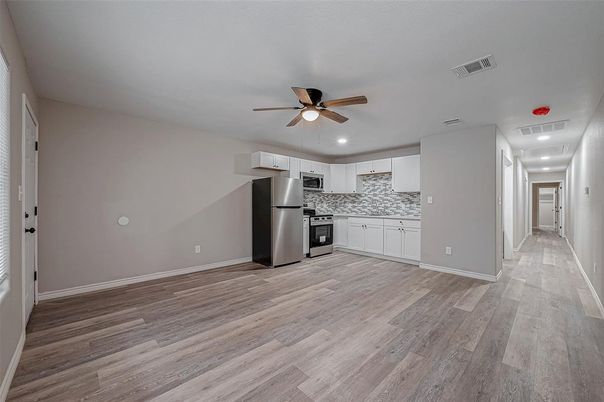Empty room, Interior, Kitchen, Recessed Lighting, Stainless Steel Appliances, Wood Texture Flooring