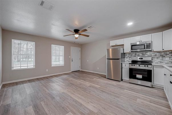 Empty room, Interior, Kitchen, Recessed Lighting, Stainless Steel Appliances, Wood Texture Flooring