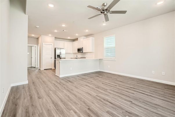 Empty room, Interior, Kitchen, Recessed Lighting, Stainless Steel Appliances, Wood Texture Flooring