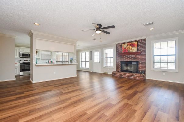 Empty room, Fireplace, Interior, Kitchen, Recessed Lighting, Stainless Steel Appliances, Stone Walls, Wood Texture Flooring