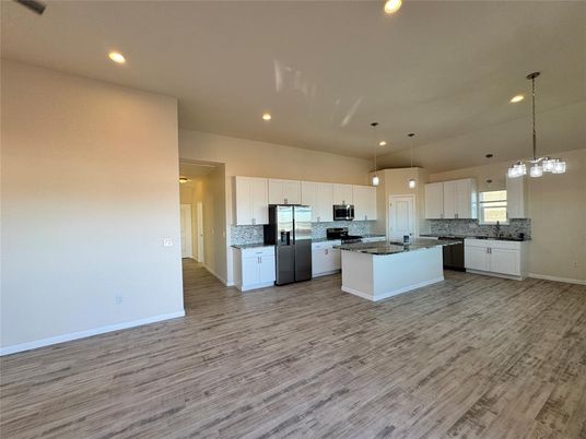 Empty room, Interior, Kitchen, Pendant Lights, Recessed Lighting, Stainless Steel Appliances, Wood Texture Flooring