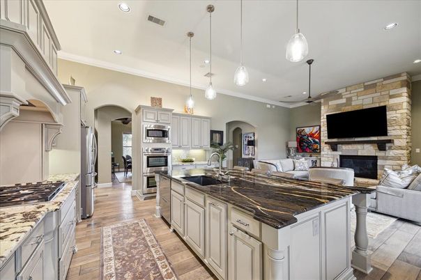 Fireplace, Interior, Kitchen, Pendant Lights, Recessed Lighting, Stainless Steel Appliances, Stone Walls, Wood Texture Flooring