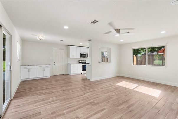 Empty room, Interior, Kitchen, Recessed Lighting, Stainless Steel Appliances, Wood Texture Flooring