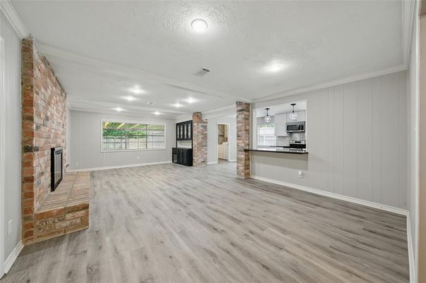 Empty room, Fireplace, Interior, Kitchen, Recessed Lighting, Stainless Steel Appliances, Stone Walls, Wood Texture Flooring
