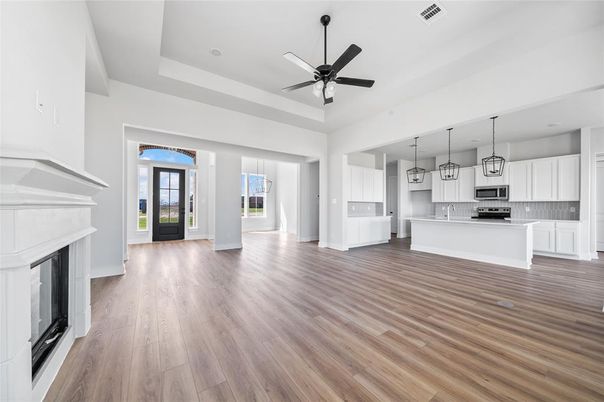 Empty room, Fireplace, Interior, Kitchen, Pendant Lights, Stainless Steel Appliances, Wood Texture Flooring