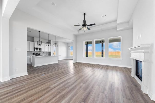 Empty room, Fireplace, Interior, Kitchen, Pendant Lights, Recessed Lighting, Stainless Steel Appliances, Wood Texture Flooring